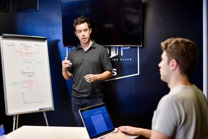 Team members working on computer and blackboard