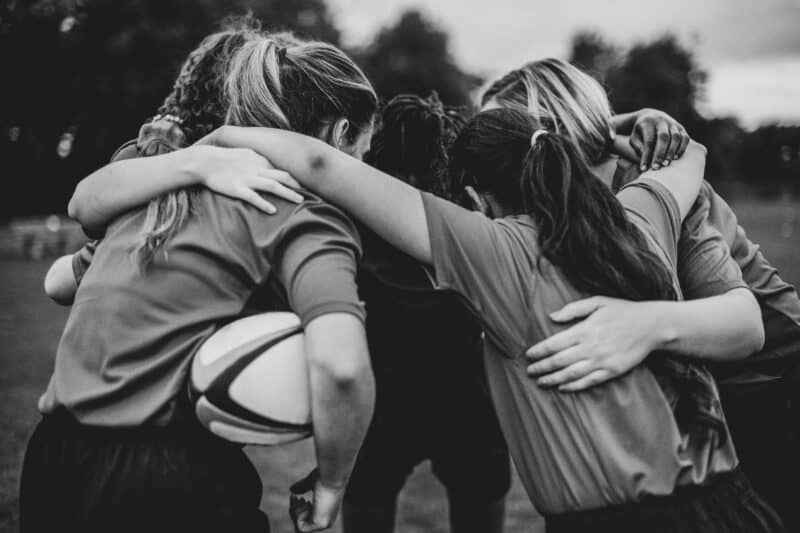 women huddling on a rugby match